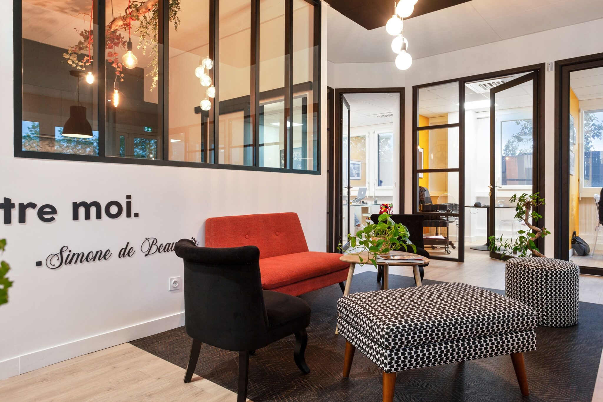 Espace détente et discussion chaleureux avec vue sur les bureaux vitrés