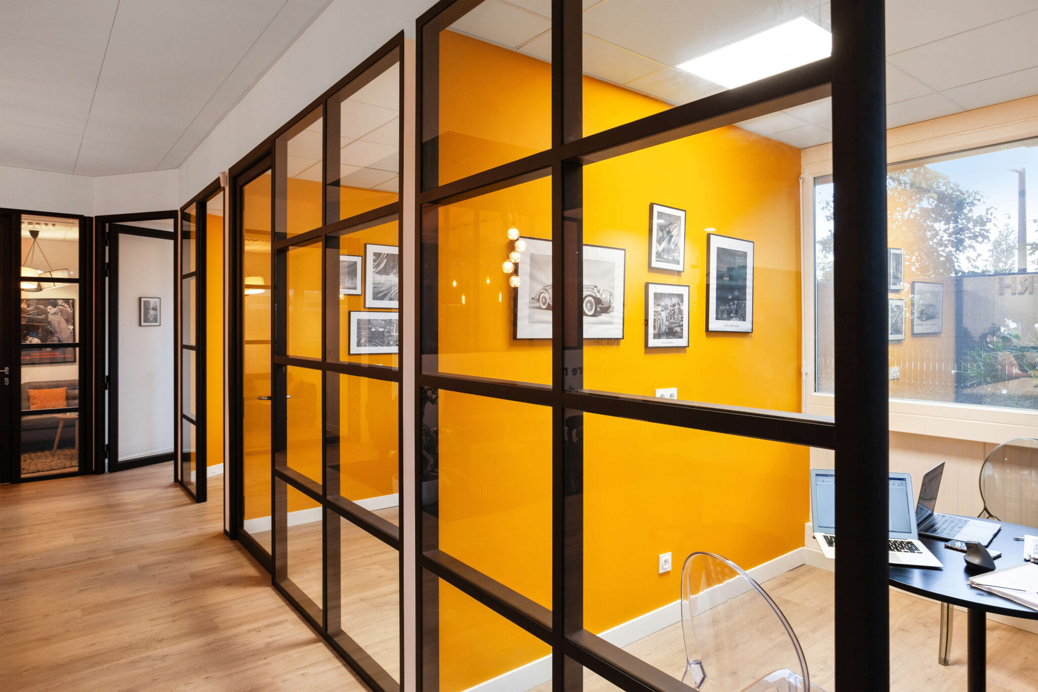 Vue depuis le couloir sur les bureaux vitrés de Cofabrik RH avec verrière noire