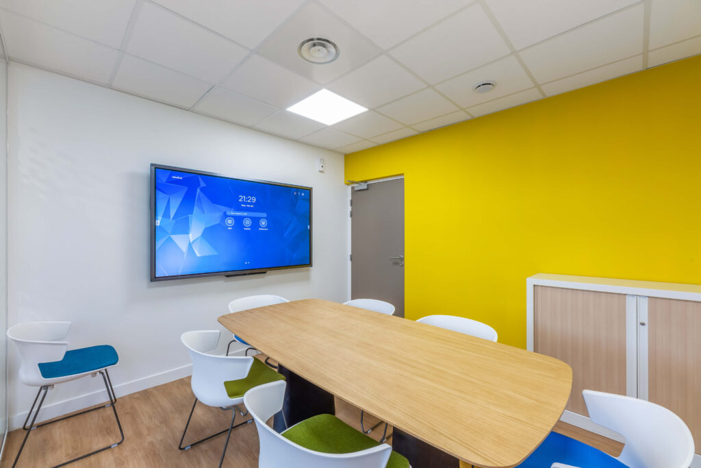 Salle de réunion fermée avec pan de mur jaune
