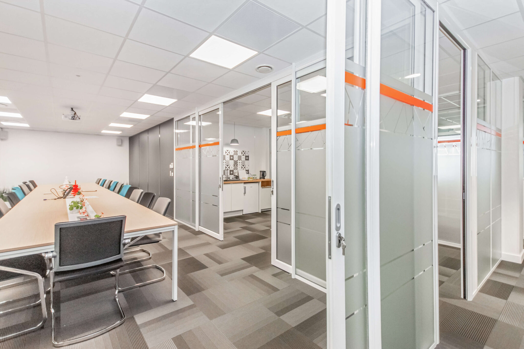 Vue sur une salle de réunion avec baies vitrées coulissantes composées de vitrauphanie